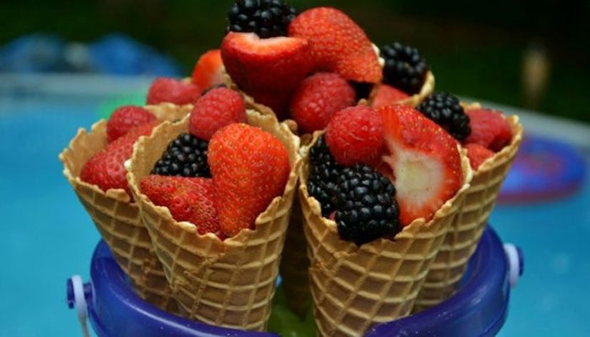 A bucket with fresh fruit cones, strawberries and blackberries on the list of the 10 great recipes f...