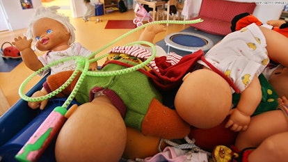 A pile of baby dolls on one place together with some other toys