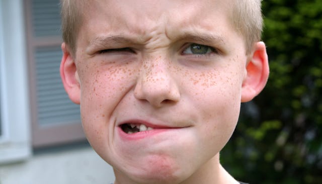 A blonde boy with an angry facial expression