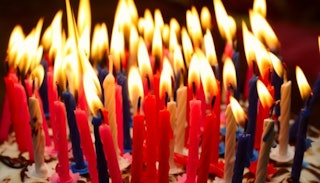 A birthday cake with a lot of red, white, and blue candles for a 39th birthday