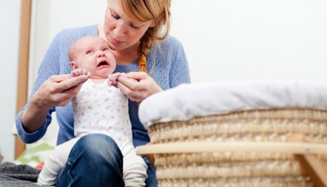 New mother playing with her crying baby
