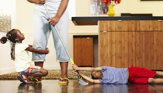 Children hanging on their stay-at-home mom while she is cleaning