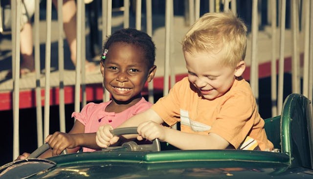 A boy and a girl riding bumper cars together