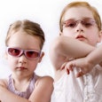 Two girls wearing vintage sunglasses posing