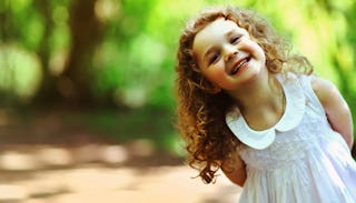 Little curly-haired girl dressed in a white dress 