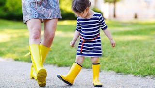 A mom who is not best friends with her daughter, both wearing yellow rain boots