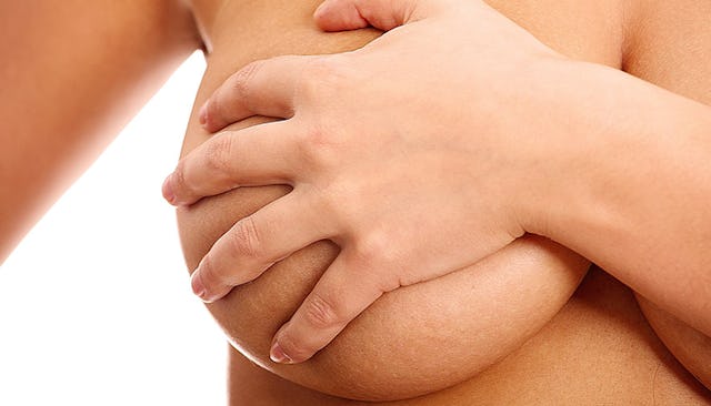 Woman holding her boob with a hand