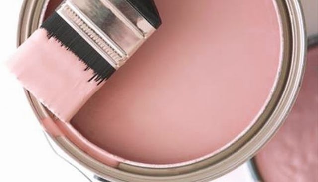 A bucket with pink paint and a paint brush, for a pink room