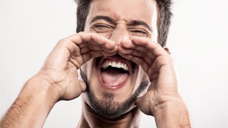 A man shouting with his hands placed near his mouth