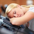 Tired mom wanting to sleep on a treadmill track in a gym