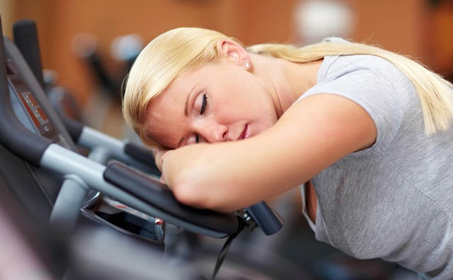 Tired mom wanting to sleep on a treadmill track in a gym