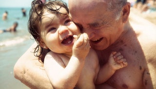 Grandpa and granddaughter having fun on the beach
