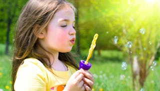 A daughter whose mom thinks she's beautiful blowing balloons outside