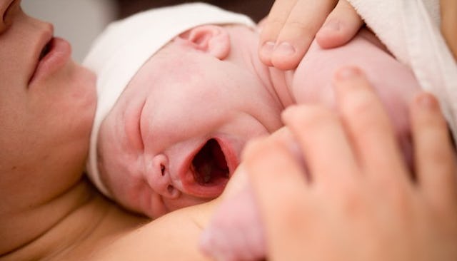 A newborn baby lying on the mother's chest