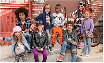 A group of kids wearing colorful outfits in the street 