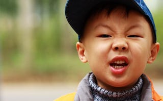 A mischievous child posing with an angry face