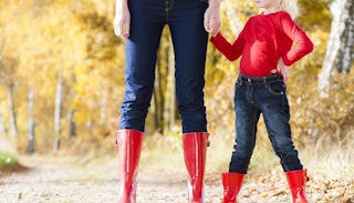 Mother and daughter standing in red boots and denim pants