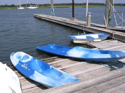 Blue kayaks on a wooden bridge next to a river in Cape May Lighthouse in New Jersey