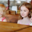 Three little kids sitting next to each other at a table
