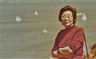 Jennifer Li Schotz's grandma posing next to the Mississippi Delta in a brown turtleneck