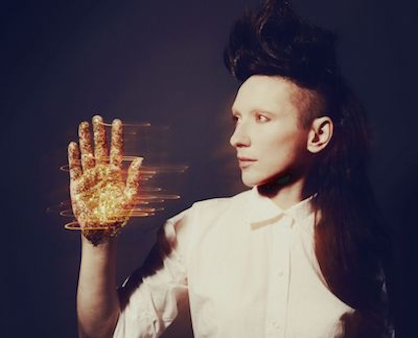 Shara Nova standing with her golden and shiny palm in the air for the My Brightest Diamond cover art...