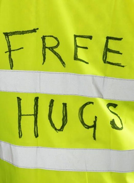The inscription "Free Hugs" on a yellow fluorescent vest.