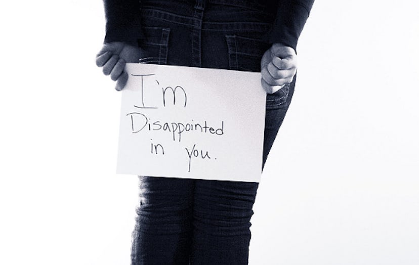 A person holding a sign that says "I'm disappointed in you"