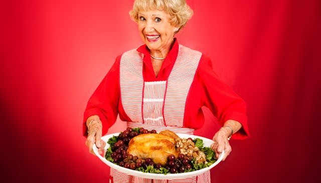 An older lady holding a Thanksgiving turkey on a plate