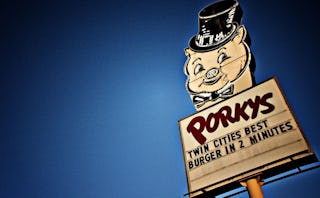 A billboard for Porkys burgers with a pig at the top of the billboard.