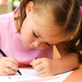 A kindergartner drawing during her class