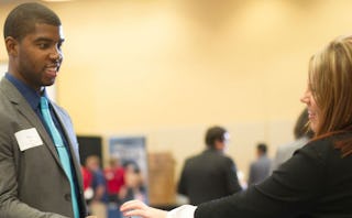 A man and woman with name tags talking about careers and smiling 