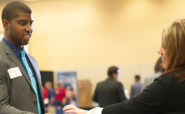A man and woman with name tags talking about careers and smiling