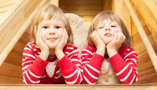 Two blonde twin toddler boys in red striped pyjamas