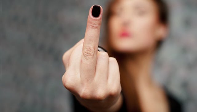 Stepmother showing a middle finger with black nail polish and face slightly blurred in the backgroun...