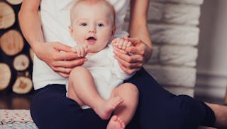 A mom with after-pregnancy side effects sitting and holding her baby in her lap