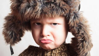 Angry boy wearing a fur cap because his mom told him to shut up