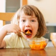 Annoyed kid eating carrot mash