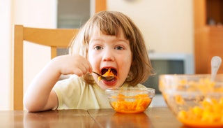 Annoyed kid eating carrot mash