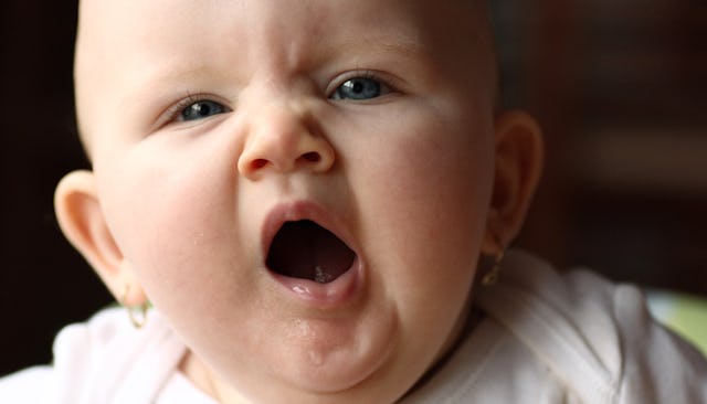 A newborn baby in the middle of yawning