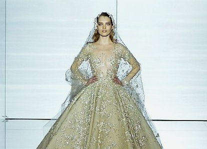 A model wearing a sequin wedding dress and a veil on a runway 