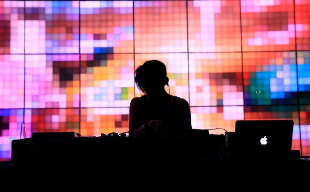 Color contrast of a DJ standing over a mixtape with dark and bright colored background behind him