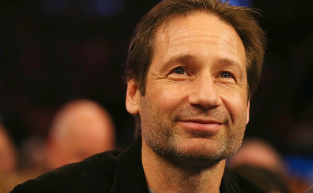 David Duchovny up whilst smiling not directly looking into the camera, wearing a  black shirt with a...