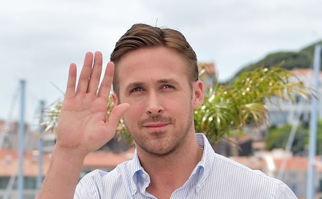 Ryan Gosling wearing a blue and white striped shirt while waving at paparazzi