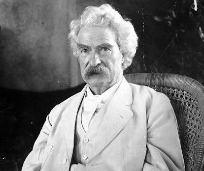 Mark Twain, author of The Adventures of Tom Sawyer with a moustache wearing a white suit 