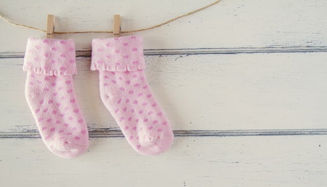 Pink baby socks with pink dots hanging from a thin rope