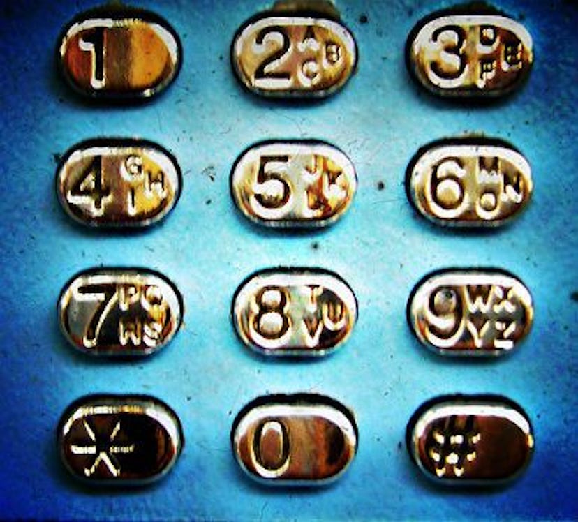 A close-up of an old blue phone's number buttons