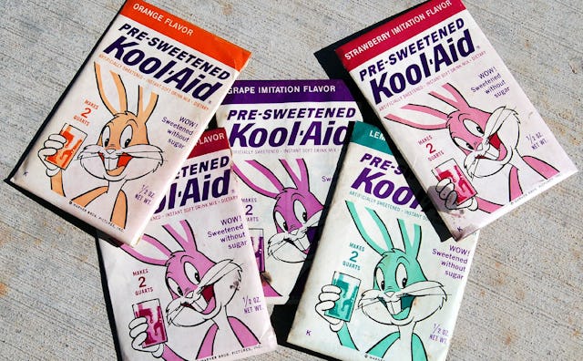 Five Kool-Aid packages of different flavors displayed on the ground