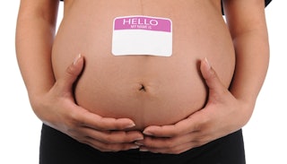 A pregnancy belly with an empty name sticker for the baby.