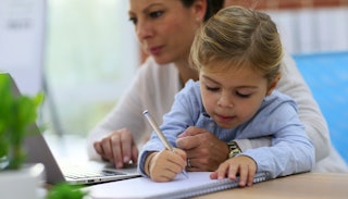 Lawyer mom looking after her daughter while working on her laptop