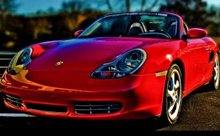 A semi-side view of a red Ferrari vehicle in a parking lot